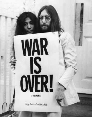 John Lennon (1940 - 1980) and Yoko Ono pose on the steps of the Apple building in London, holding one of the posters that they distributed to the world's major cities as part of a peace campaign protesting against the War. 'War Is Over, If You Want It'.   (Photo by Frank Barratt/Getty Images)